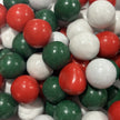 Close-up of red, green and white candy-coated chocolate balls, featuring peppermint milk chocolate balls and Jaffas in festive Christmas colours.