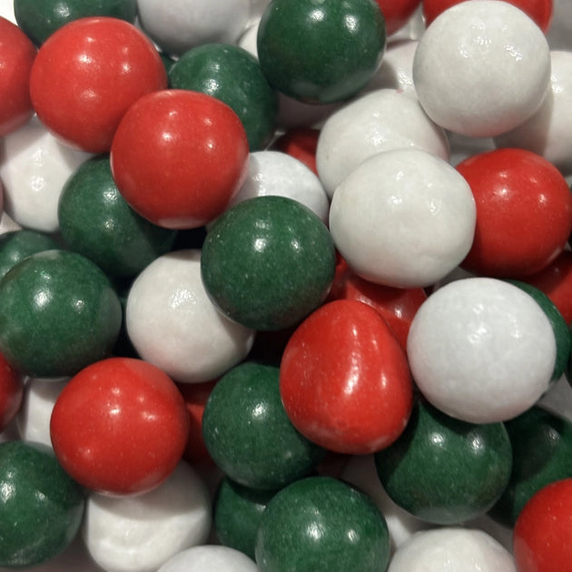 Close-up of red, green and white candy-coated chocolate balls, featuring peppermint milk chocolate balls and Jaffas in festive Christmas colours.