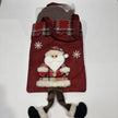 Red Christmas gift bag with Santa design, containing a large milk chocolate Santa.