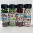 Four clear Christmas lolly tubes with black lids, filled with red and green frogs, sugared peanuts and assorted bon bons, featuring fun Christmas-themed labels.