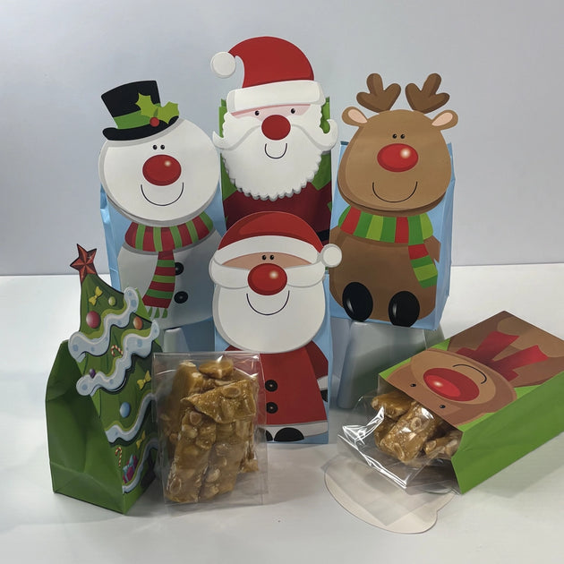 Christmas-themed gift bags with assorted festive character designs, showing pieces of golden peanut brittle packaged in clear bags.