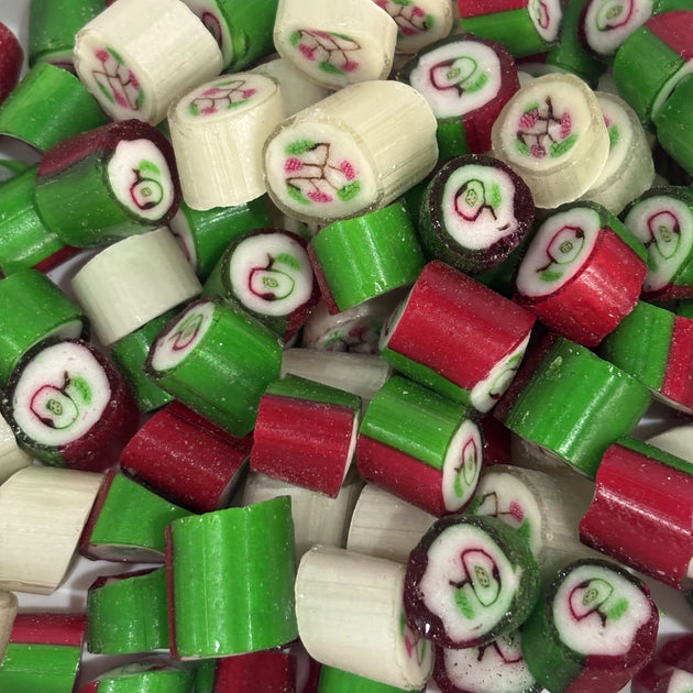 Close-up of red, green and white apple and raspberry flavoured Christmas rock candy, featuring fruit designs in the centre of each piece.