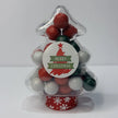 Clear Christmas tree-shaped container filled with red, green and white candy-coated peppermint chocolate balls and Jaffas. Container features a Merry Christmas sticker on the front. 