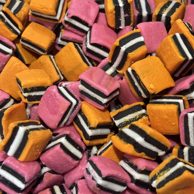 Colourful licorice allsorts with layers of black licorice and pink, orange and white fondant