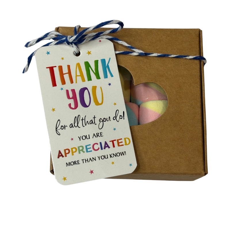 A square gift box with a heart-shaped window showing rainbow marshmallows inside, tied with string and a thank-you gift tag that reads 'THANK YOU for all that you do! YOU ARE APPRECIATED MORE THAN YOU KNOW!'