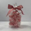 Clear gift bag filled with individually wrapped red and white striped mint baubles, finished with a red and white gingham ribbon bow
