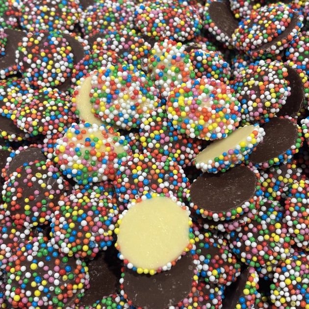 Pieces of milk and white chocolate coated in candy sprinkles