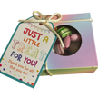 A square gift box filled with mixed rock candy, tied with a ribbon and featuring a gift tag that reads 'JUST A LITTLE TREAT FOR YOU! Thank you for all that you do!'.