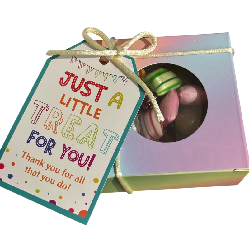 A square gift box filled with mixed rock candy, tied with a ribbon and featuring a gift tag that reads 'JUST A LITTLE TREAT FOR YOU! Thank you for all that you do!'.