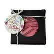 A gift box wrapped with twine and a 'Happy Birthday' gift tag, featuring a clear circular window that reveals pink mini musk sticks inside.