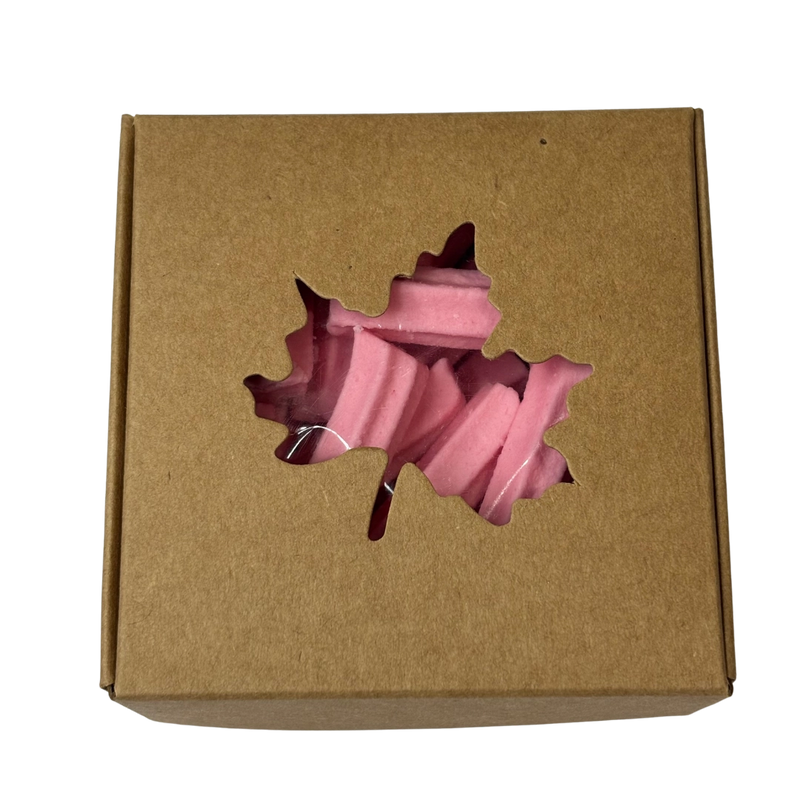 A square gift box with a leaf-shaped cutout on the lid, revealing pink mini musk sticks inside.