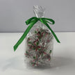 Clear gift bag filled with individually wrapped red, green and white Starlight Mints, tied with a ribbon.