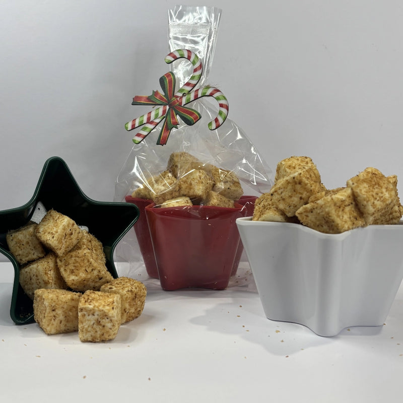 Toasted marshmallows in a star-shaped bowl, wrapped in cellophane with a festive candy cane decoration.