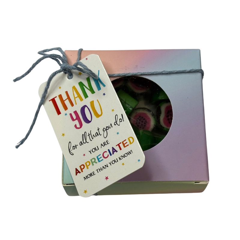 A square gift box with a circular window showing green and pink watermelon rock candy inside, tied with a string and a thank-you tag that reads 'THANK YOU for all that you do! YOU ARE APPRECIATED MORE THAN YOU KNOW!'